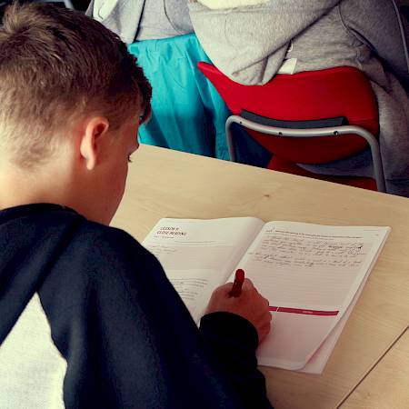 ISSFT student writing in their textbook