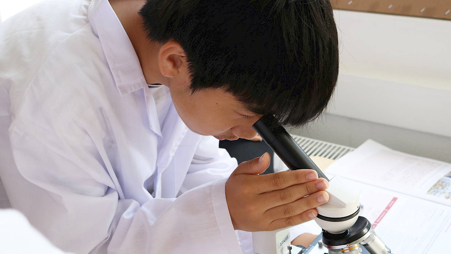 ISSFT student looking into a microscope