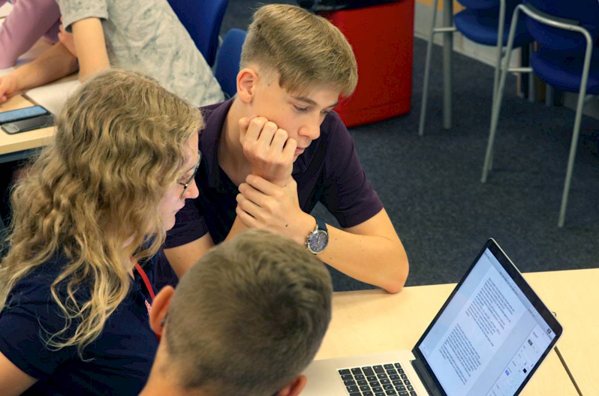ISSFT students huddled around a laptop