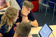 ISSFT students huddled around a laptop