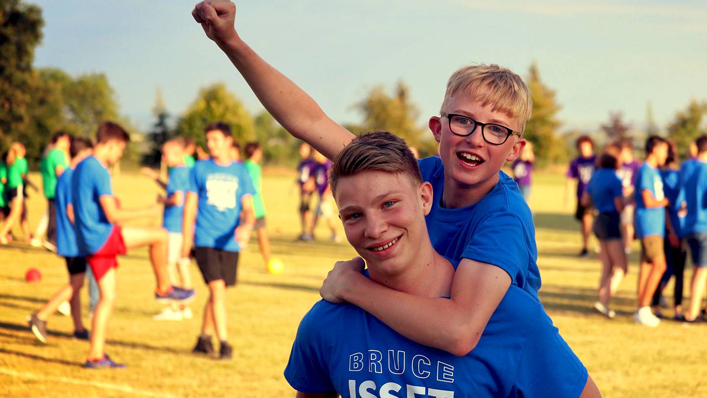 One ISSFT student carrying another ISSFT student on their back celebrating